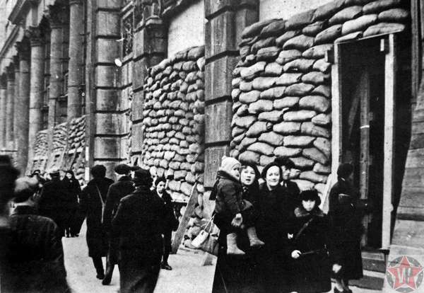 Жители на улице блокадного Ленинграда у зданий
