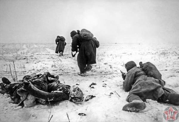Красноармейцы продвигаются по полю возле тела немца под Сталинградом